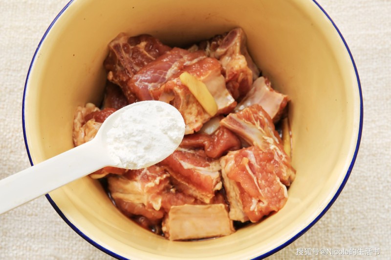 Sau khi ướp đủ thời gian, cho bột năng vào sườn, trộn đều để lớp bột áo bám quanh.